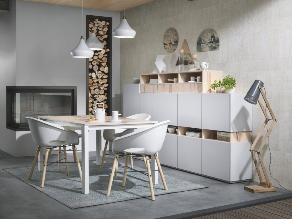 Vue d'ensemble de la salle à manger Arcos Loft coloris bois clair Ikori et gris clair Celest, avec la table Expando et les chaises Globe au premier plan et le buffet sur le côté.