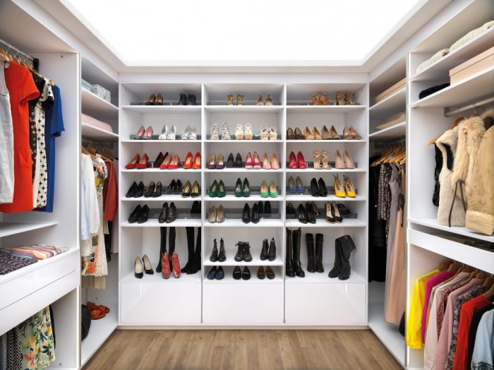 Vue de face de l’intérieur du dressing coloris blanc neige Arcos Strass, aménagé avec : compartiments de rangement, étagères, penderies courtes, porte-pantalons, tiroirs coulissants, bloc coulissant et étagères sacs à main.