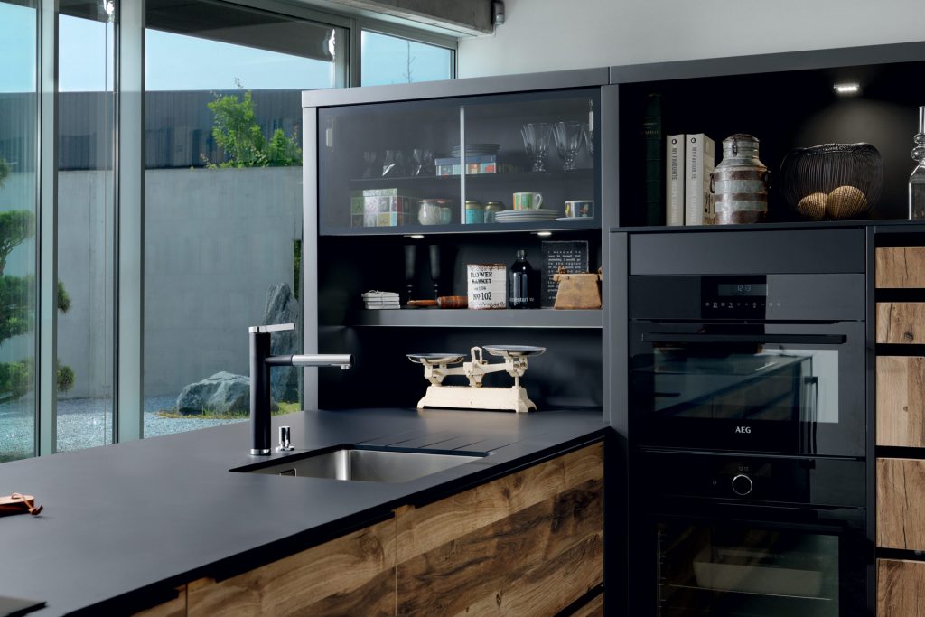 Vue de biais du plan de travail stratifié Compact coloris noir Nano Black avec cuve sous plan dans la cuisine Arcos Edition.