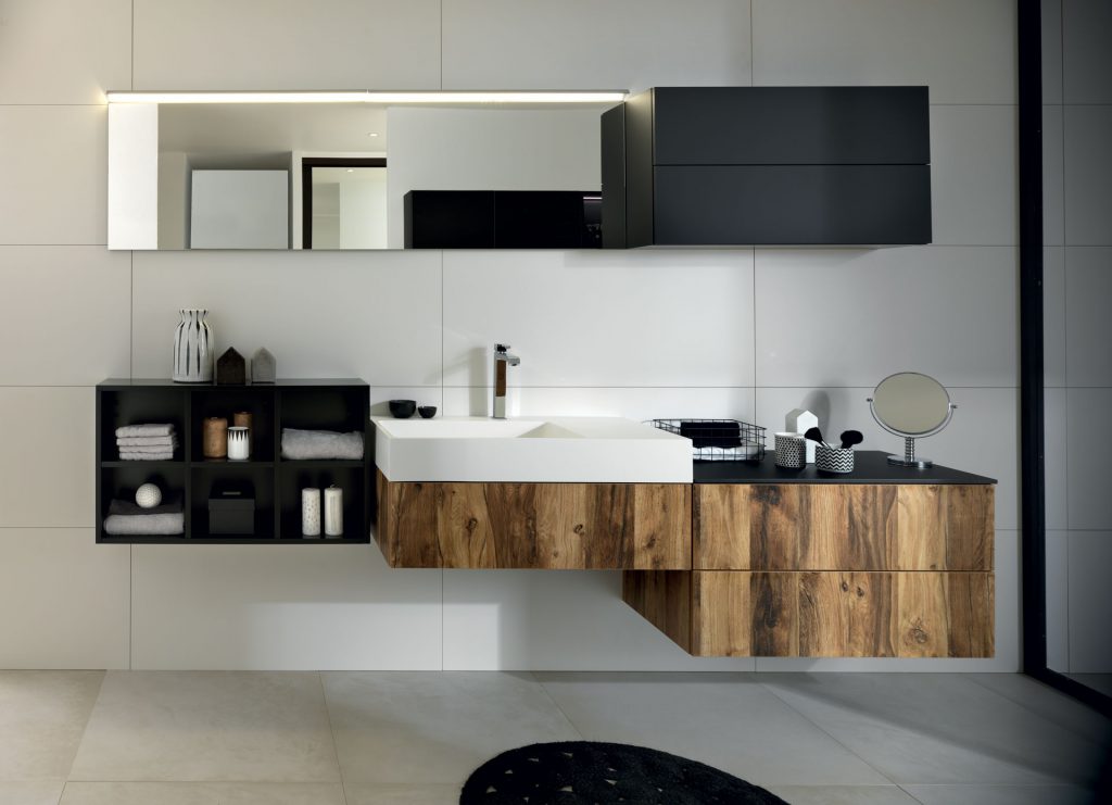 Vue de face de la vasque et du plan de toilette face au miroir de la salle de bains Arcos Edition, coloris marron clair effet bois et noir.