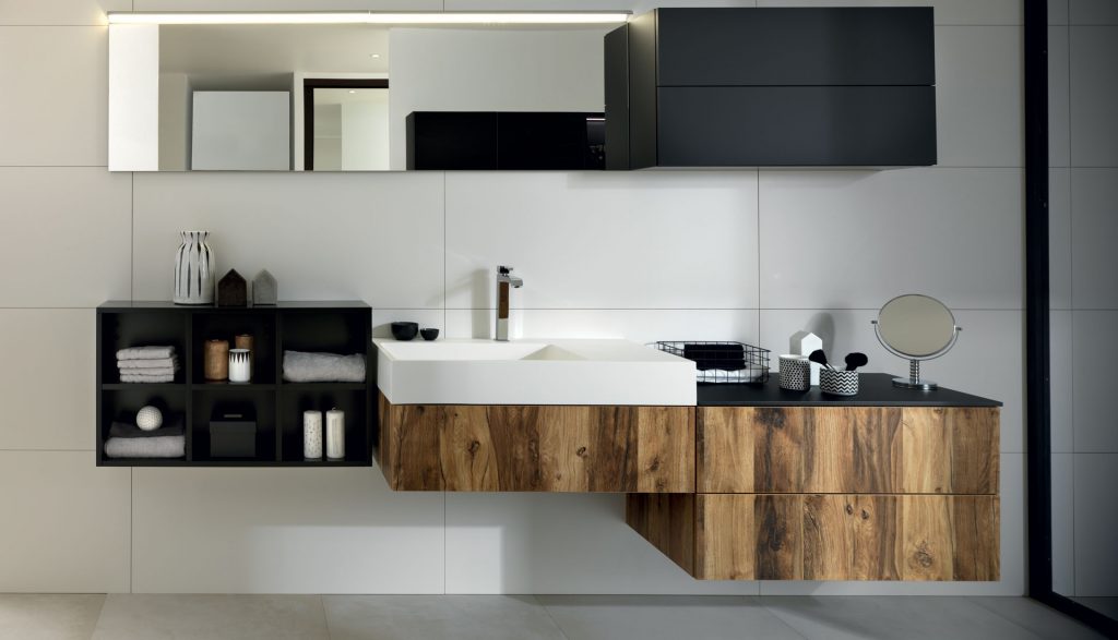 Vue de face de la vasque et du plan de toilette face au miroir de la salle de bains Arcos Edition, coloris marron clair effet bois et noir.