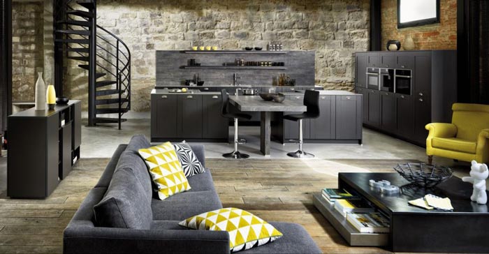 Vue d’ensemble de la cuisine Frame couleur gris foncé mat Caneo avec une vue du salon au premier plan, le canapé dans le champ.