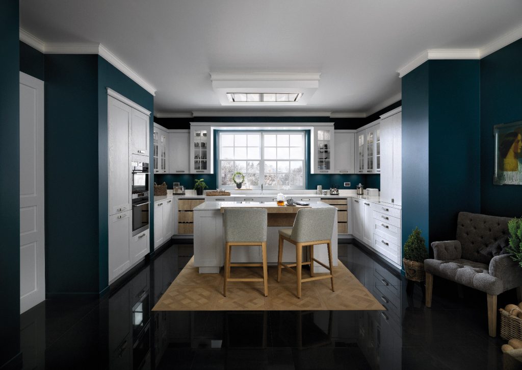 Vue d’ensemble de la cuisine Nebraska, coloris gris clair, avec un îlot central, façades blanches et Buffet-Déco couleur bois.