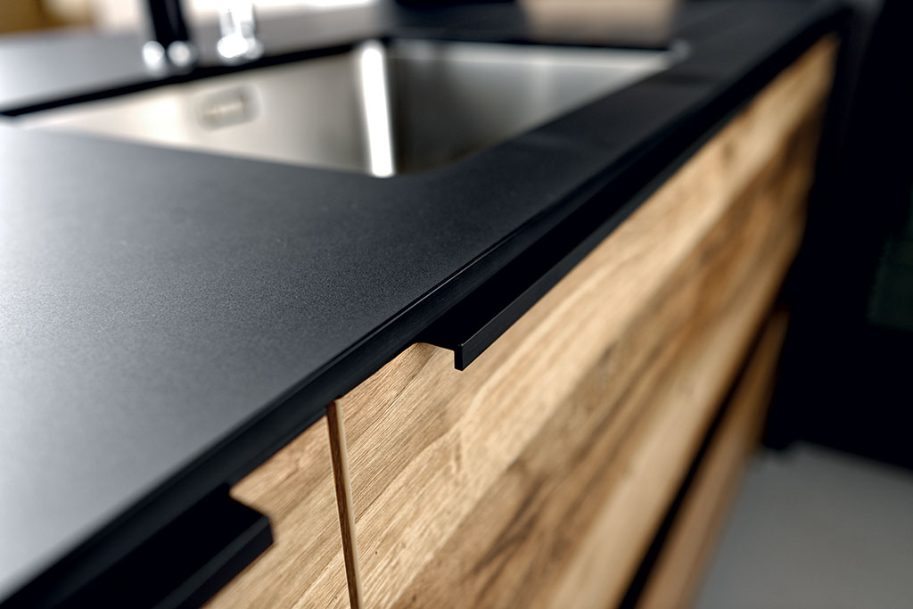 Zoom du chant du plan de travail stratifié Compact noir de la cuisine Arcos Edition, ambiance Wild Black.