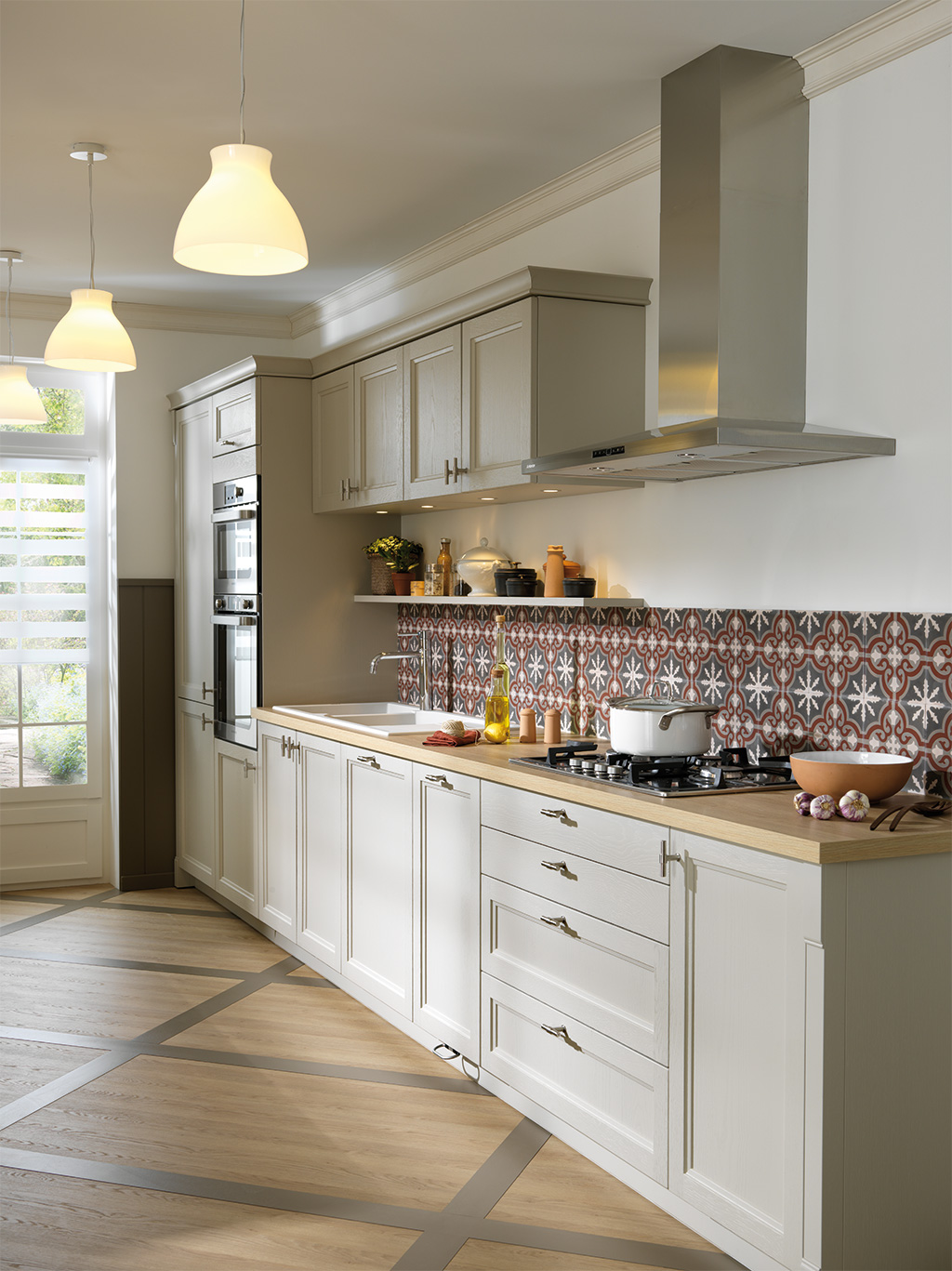 Cuisine en coloris grège clair et plan de travail en bois, avec une crédence avec des formes géométriques.