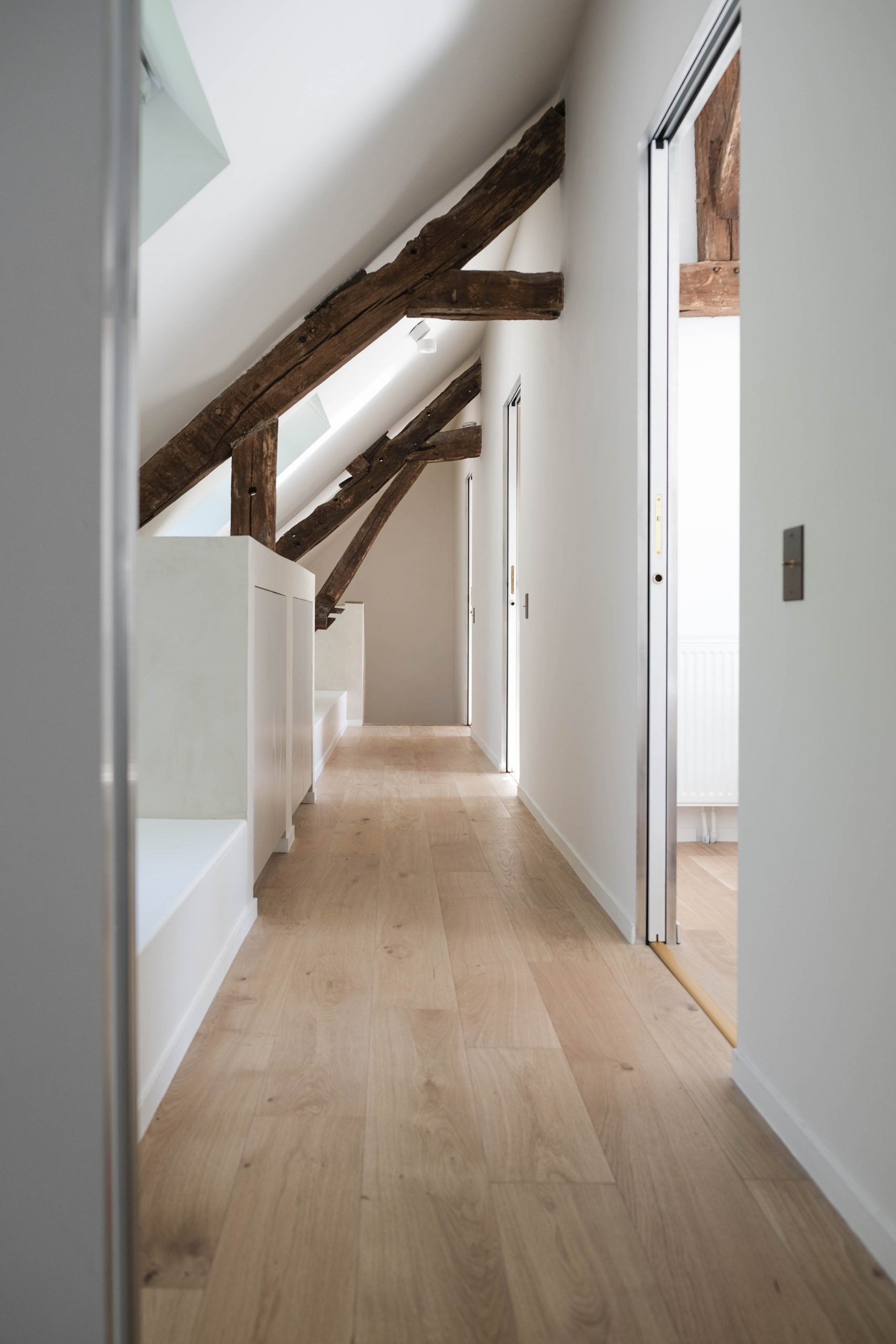 Grâce aux velux et aux tons blancs, ce couloir est naturellement éclairé.