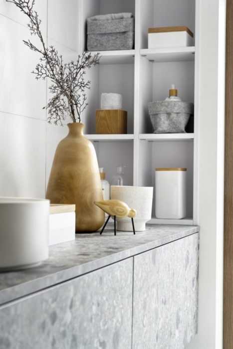 Le gris terrazzo de cette salle de bain est contrasté par de petits éléments en bois. 