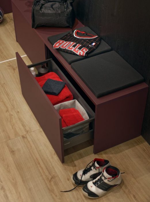 Banco de vestuario con gavetas correderas para guardar toallas de baño.