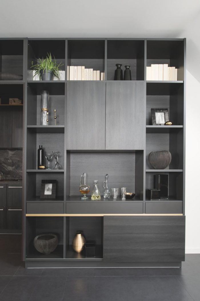La fine gorge dorée apporte une touche élégante et raffinée à cette bibliothèque noire.