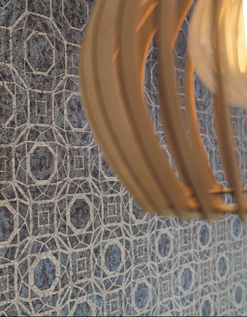 Ce papier peint aux motifs dorés donne un style art-déco à une pièce de vie.