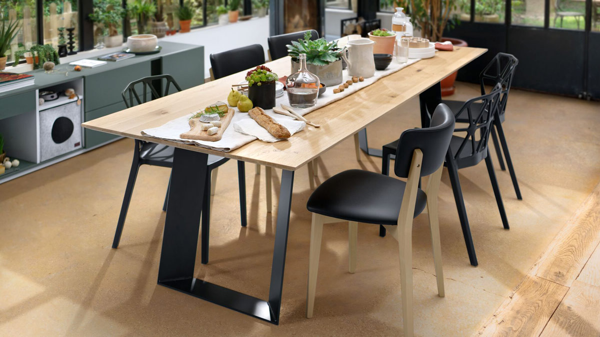 Table en métal modèle BRIDGEWOOD avec plateau en chêne massif. Chaises noires modèle TRUSS.