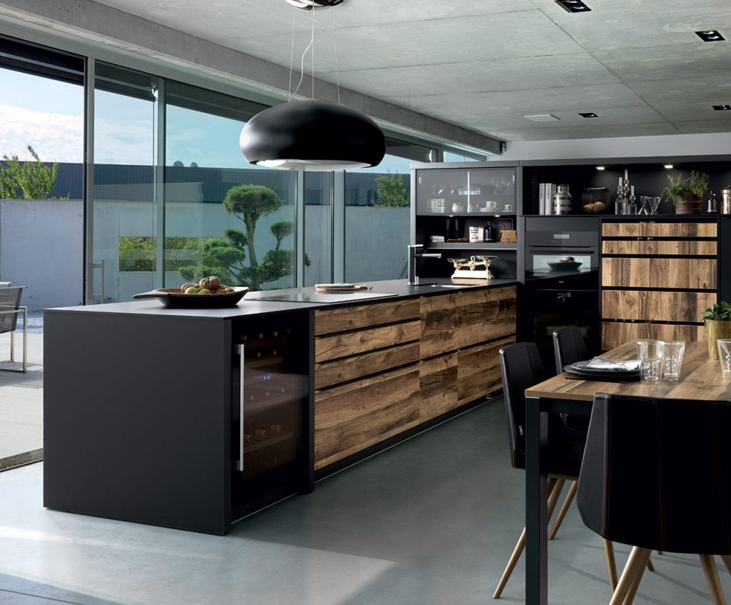 Vue d'ensemble de la cuisine Arcos Edition avec les façades couleur marron clair effet bois Murphy et le plan de travail fin coloris noir Nano Black.