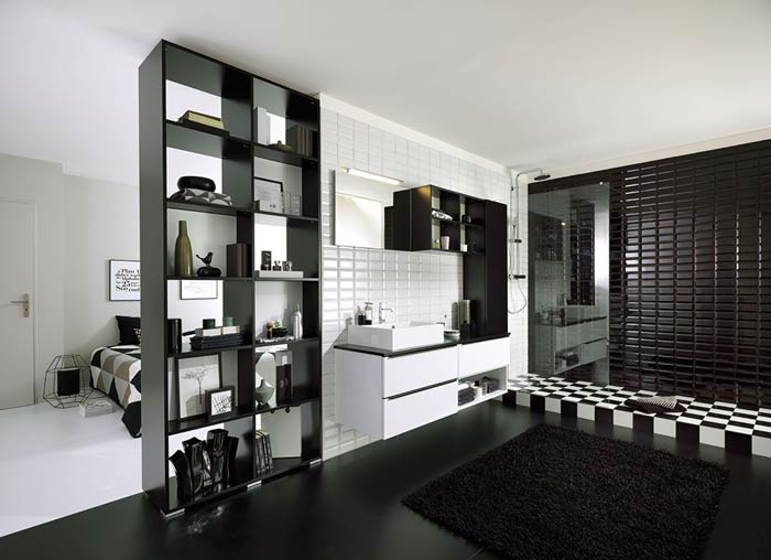 Vue d'ensemble de la salle de bains en noir et blanc avec la chambre en arrière plan et le meuble de rangement niches ouvertes et fermées au premier plan.