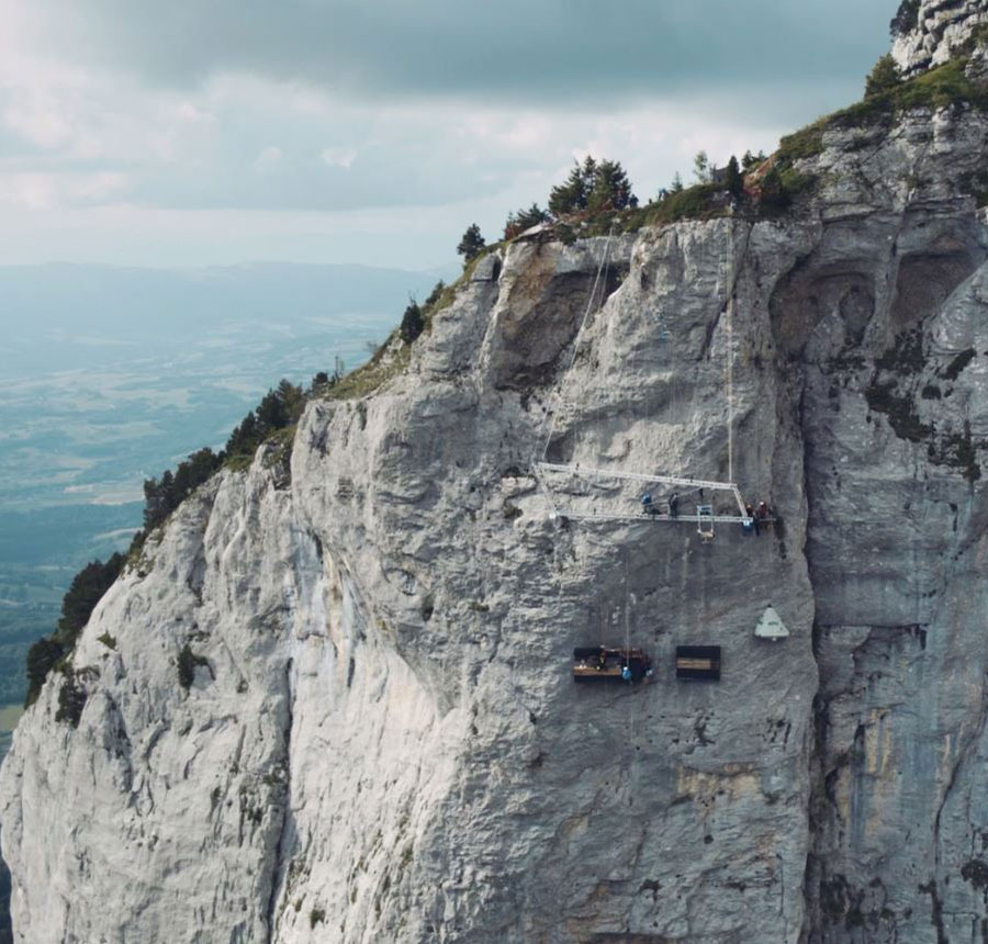 Vue d'ensemble de la montagne du Parmelan avec la cuisine, dressing et tente installés sur la falaise avec le grill au dessus